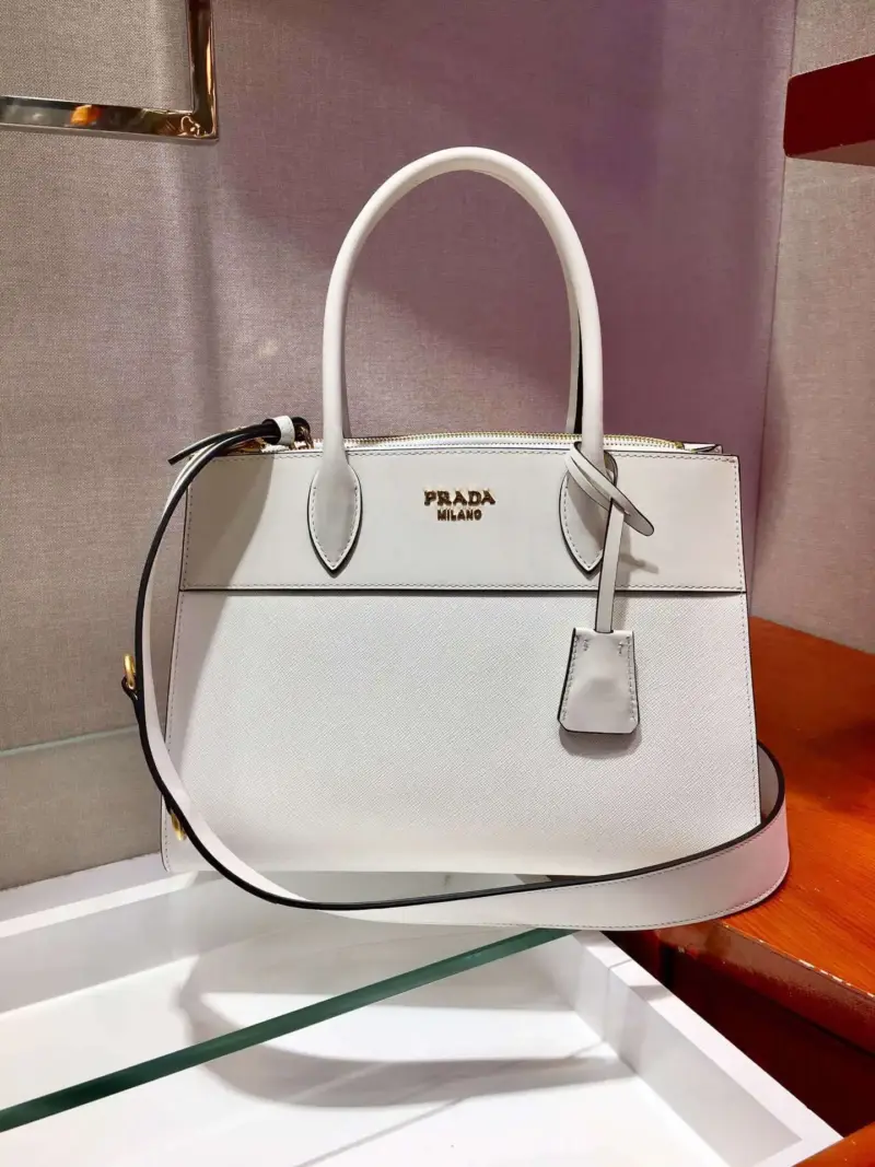 Structured-Paradigme-Top-Handle-Bag-in-Saffiano-Leather-1BA102-1-White-Structured-Paradigme-Top-Handle-Bag-in-Saffiano-Leather-1BA102-1-White-1.webp